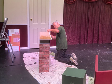 Director Anthony Whitehouse helps build the set